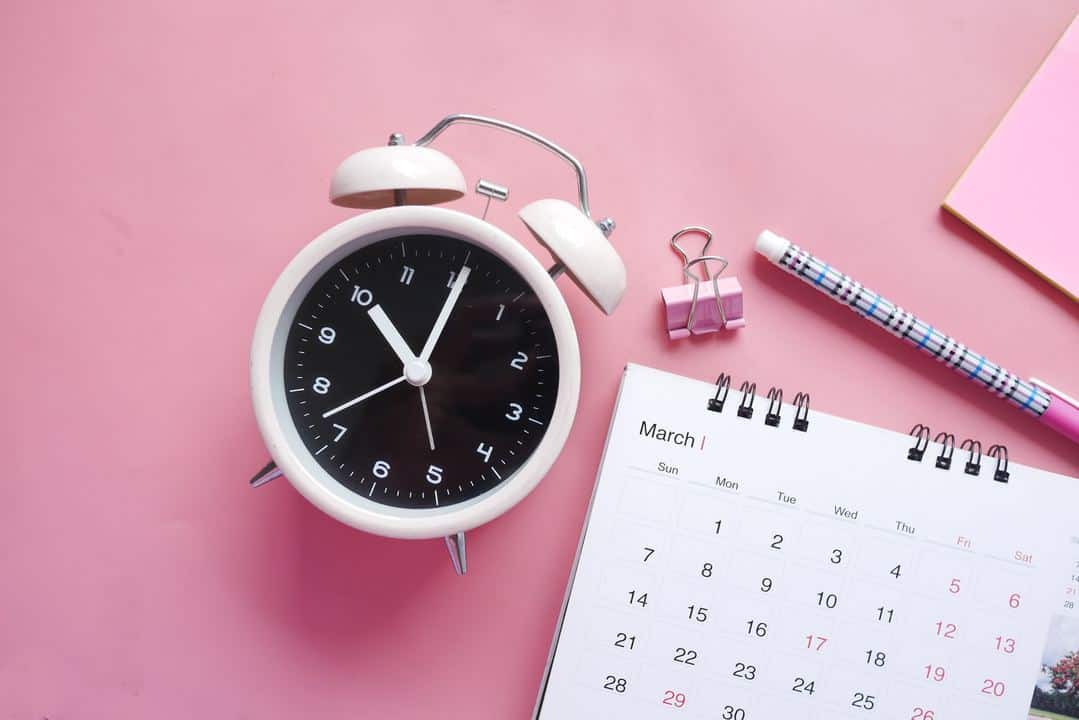 white and pink analog alarm clock