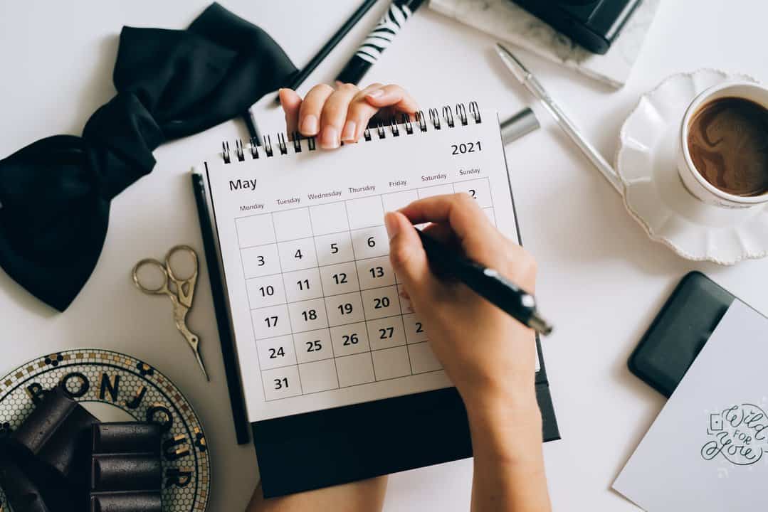 a person writing on a desk calendar